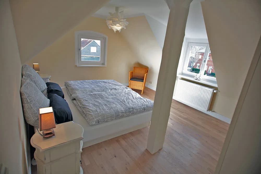 Schlafzimmer der Atelier-Wohnung der Villa Emmilio unter der Dachschräge, möbliertes Apartment in Bad Oeynhausen.
