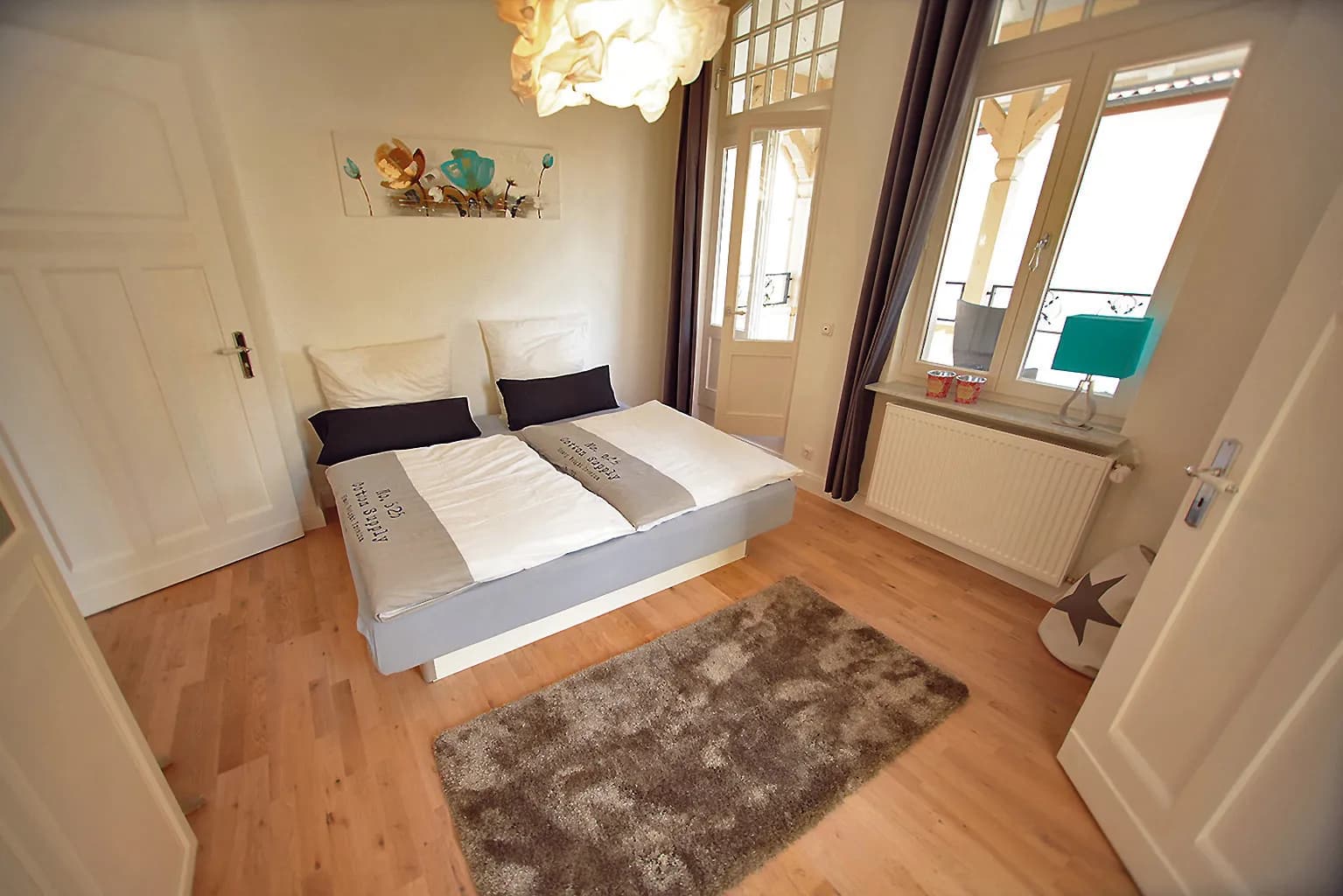 Schlafzimmer der Bel-Étage-Wohnung der Villa Emmilio mit Rundbogenfenstern, Boardinghaus in Bad Oeynhausen.