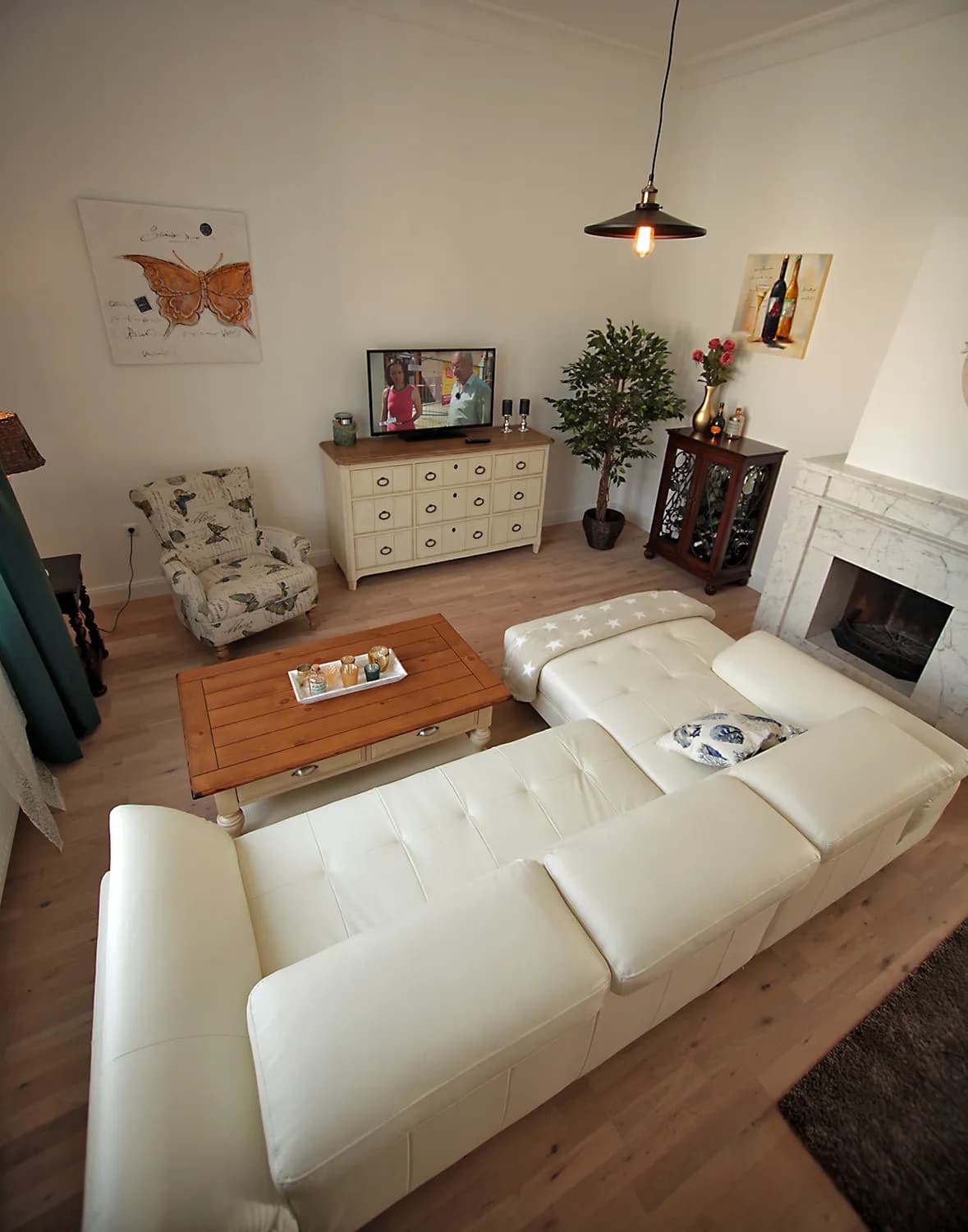 Wohnbereich der Bel-Étage-Wohnung der Villa Emmilio mit Sofa und Kamin, Wohnen auf Zeit in Bad Oeynhausen.