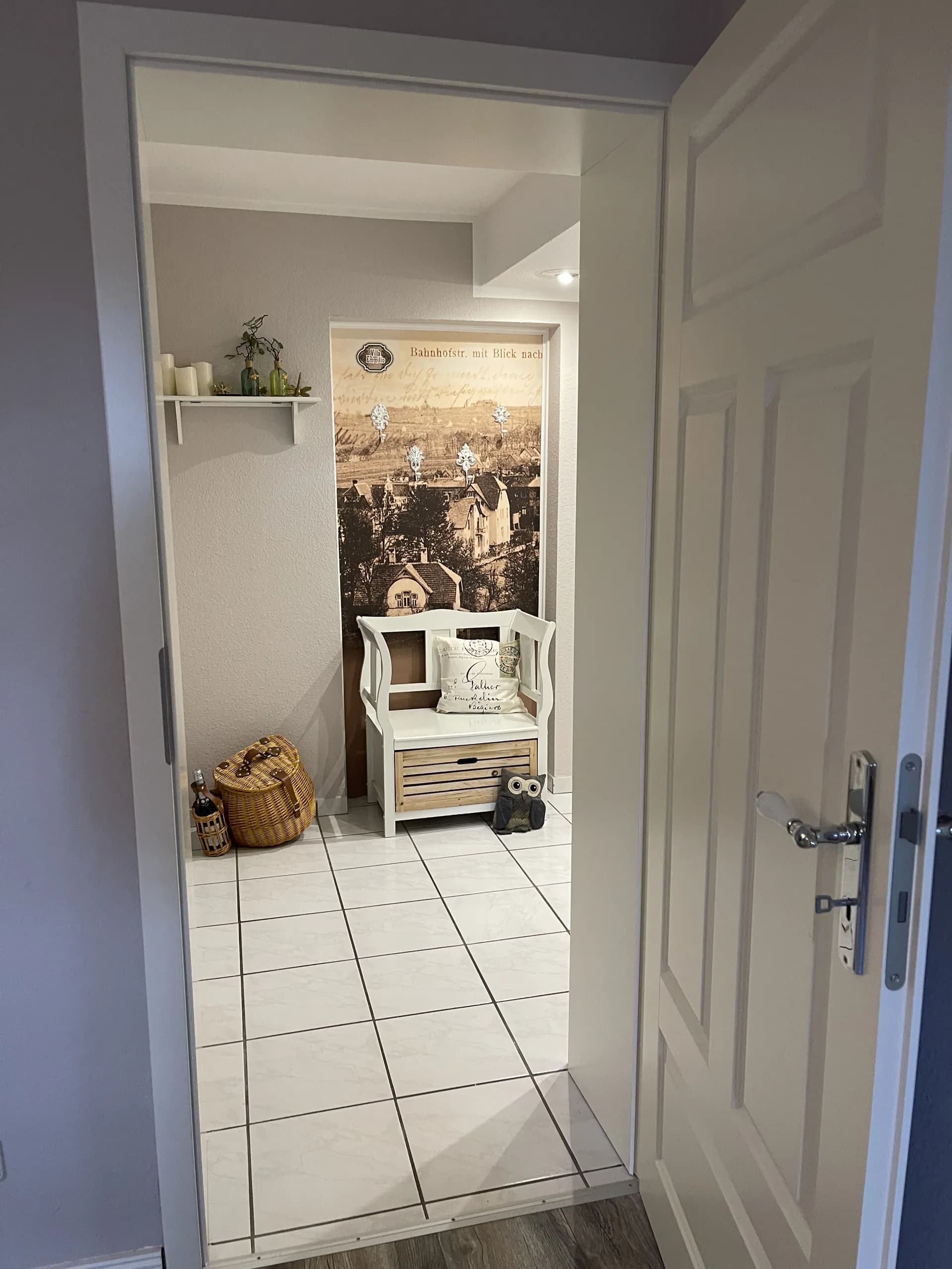 Eingangsflur der Souterrain-Wohnung der Villa Emmilio mit Sitzbank und Fototapete, Wohnen auf Zeit in Bad Oeynhausen.