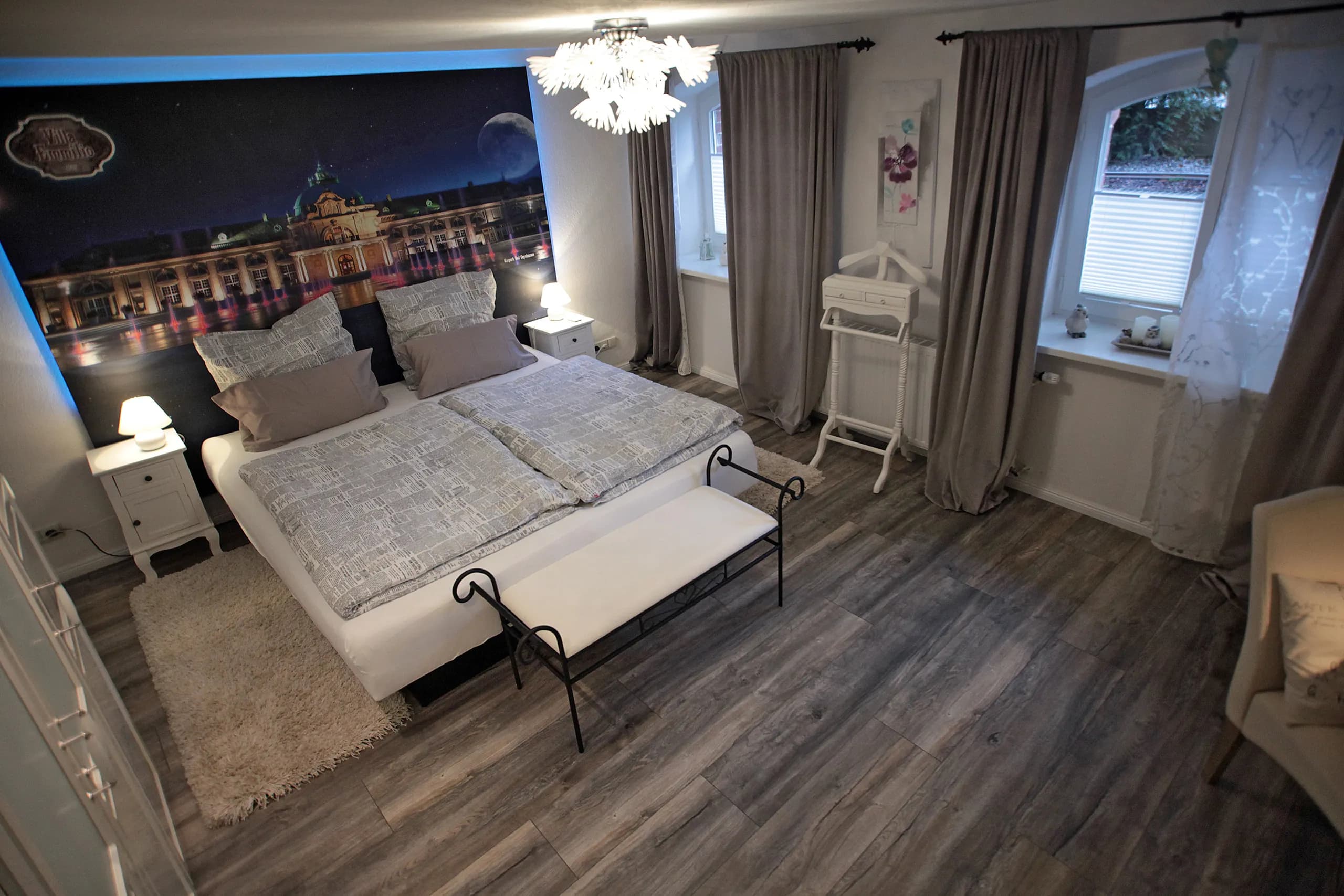 Schlafzimmer der Souterrain-Wohnung der Villa Emmilio mit Doppelbett und Parkett, Wohnen auf Zeit in Bad Oeynhausen.