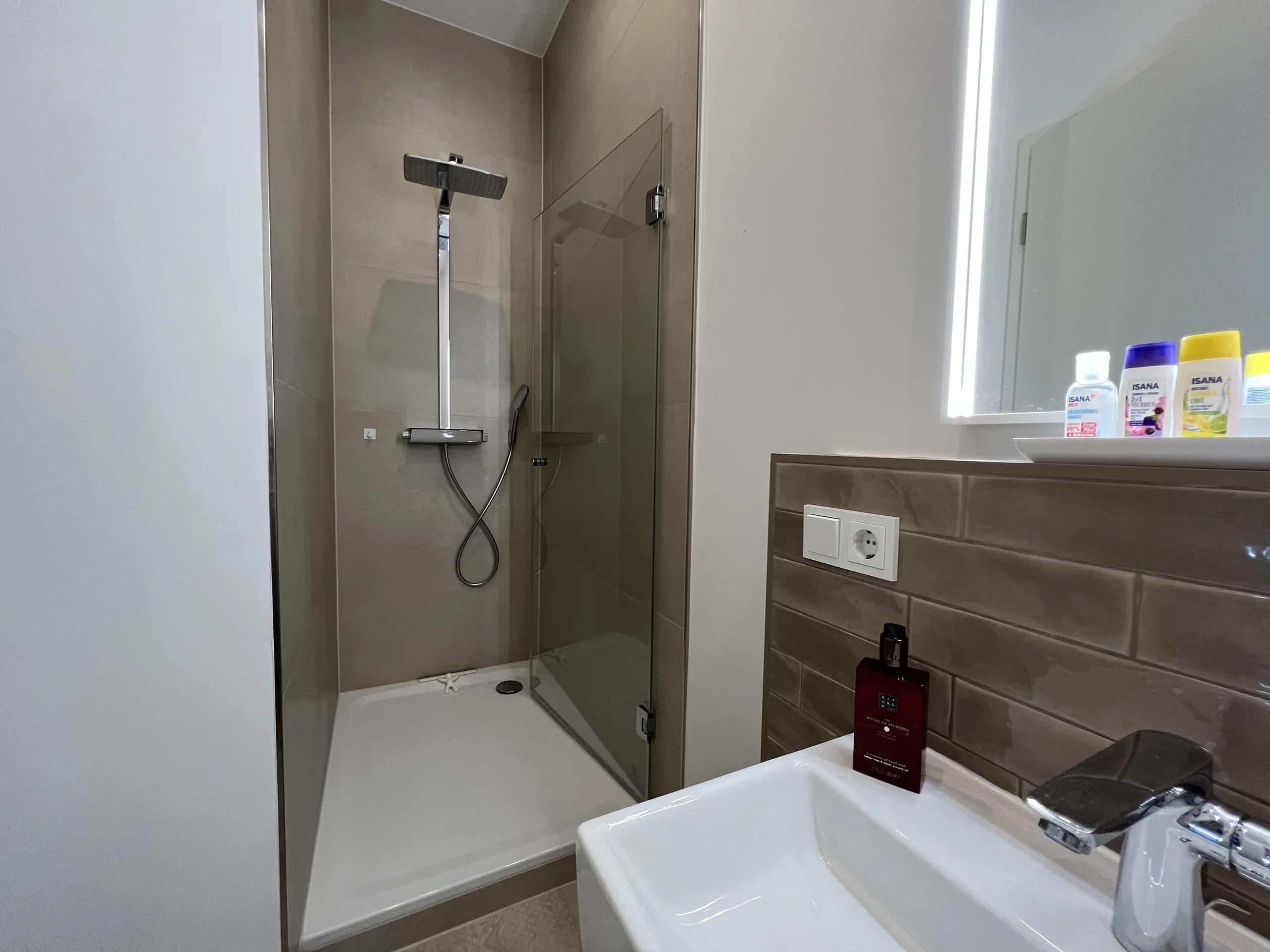 Bad der Bel-Étage-Wohnung der Villa Maria mit Walk-in-Dusche und Holz-Waschtisch, möbliertes Apartment in Bad Oeynhausen.
