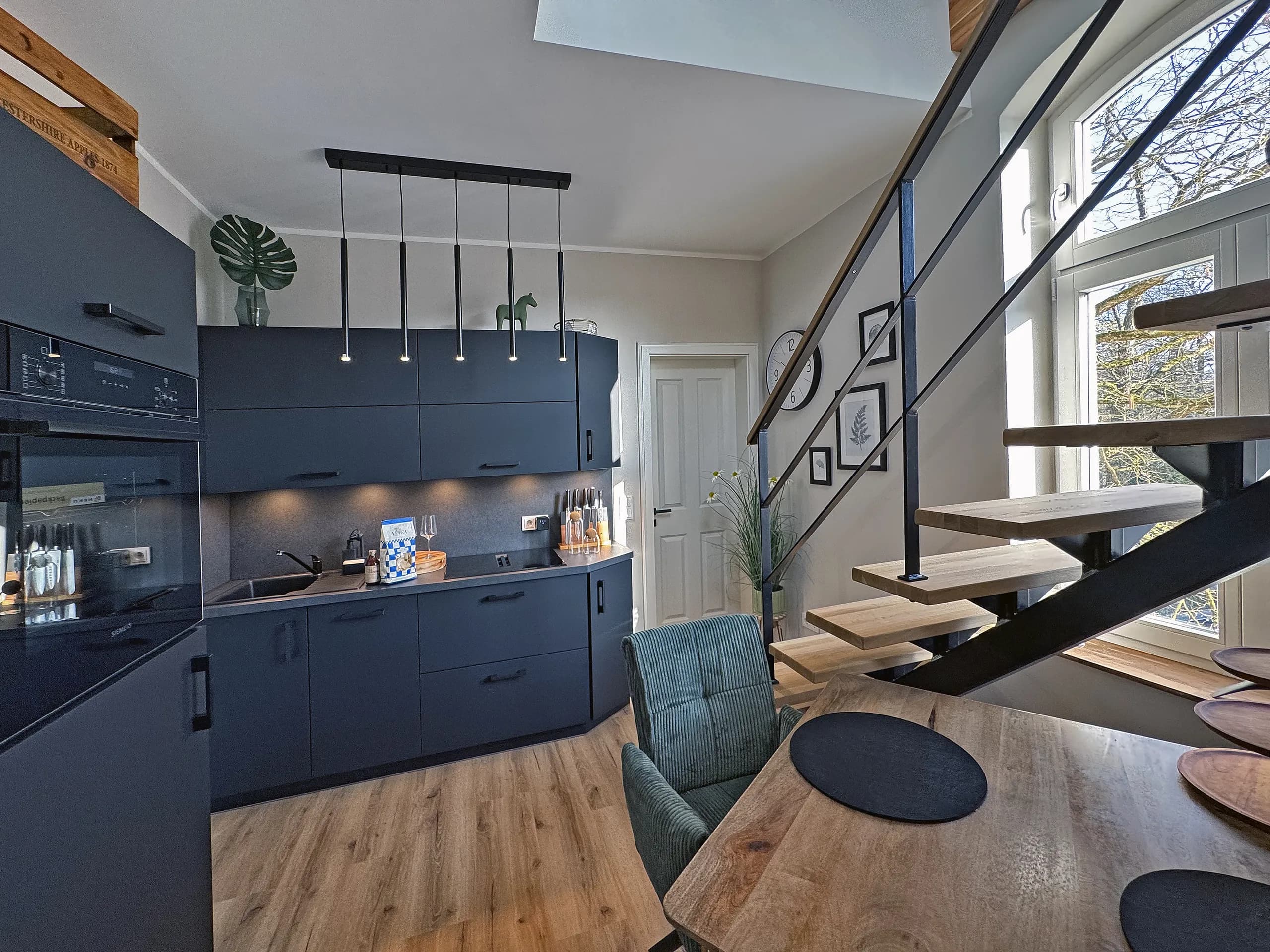 Dunkle Küche mit Maisonette-Treppe in der Wohnung Klara, möblierte Ferienwohnung in Bad Oeynhausen.