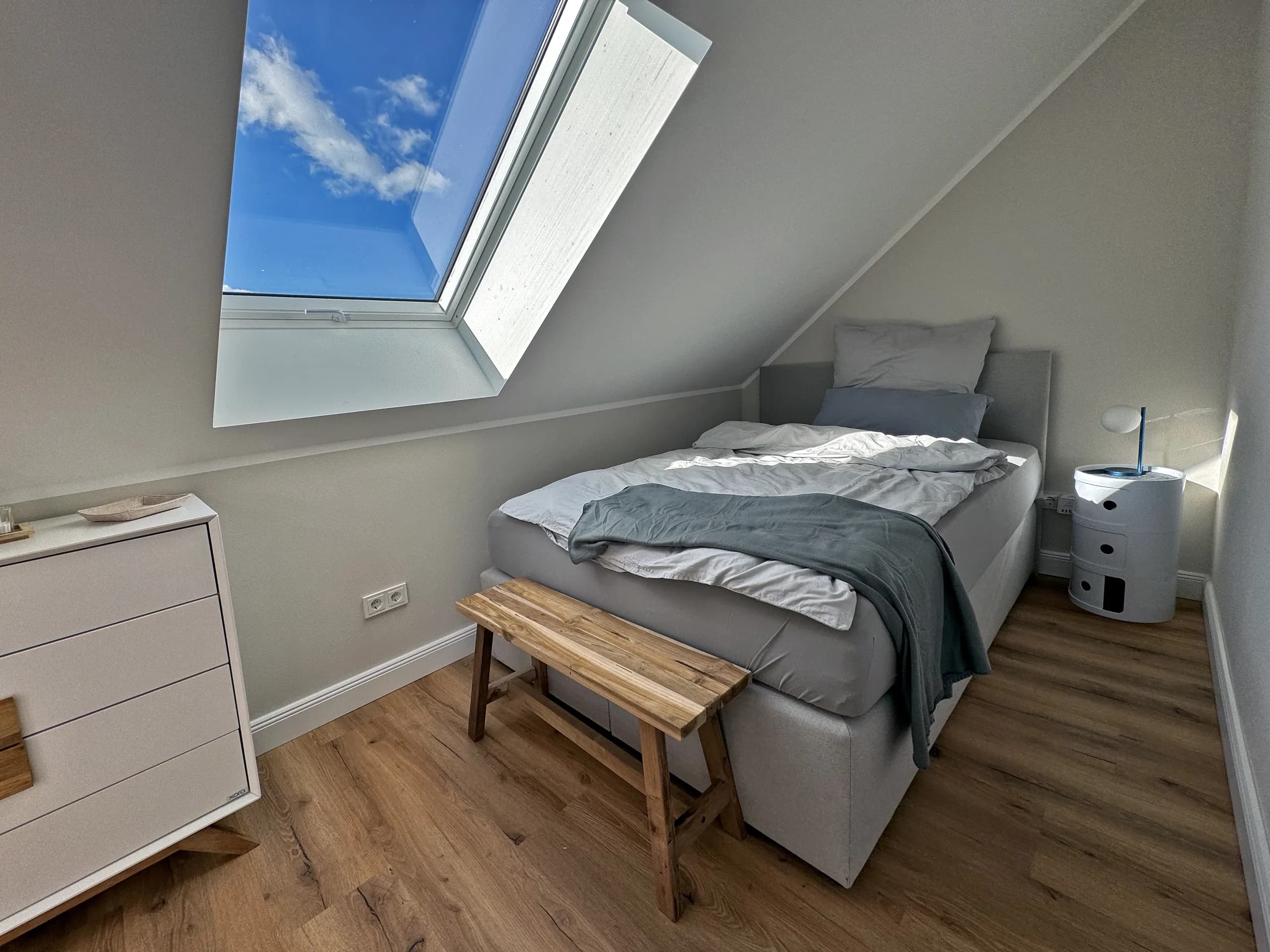 Schlafzimmer der Wohnung Klothilde mit Doppelbett unter Dachfenster, Wohnen auf Zeit in Bad Oeynhausen.