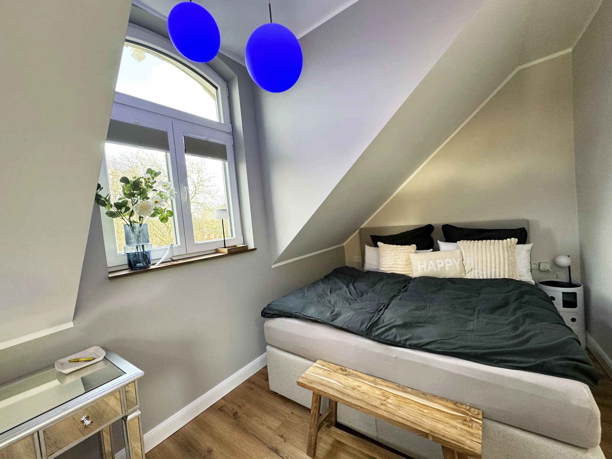 Schlafzimmer der Wohnung Vios mit Doppelbett unter Dachschräge, möblierte Ferienwohnung in Bad Oeynhausen.