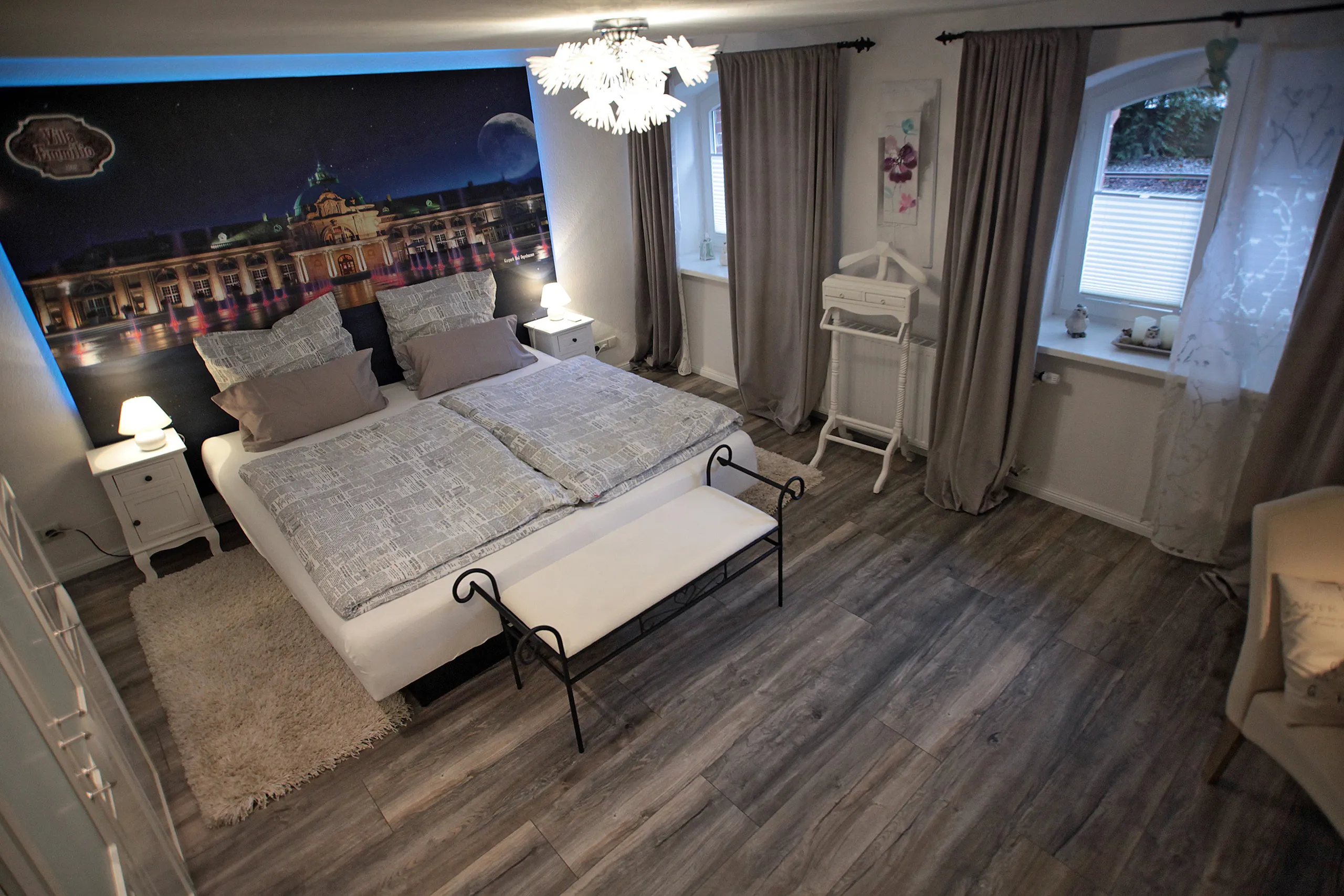 Schlafzimmer der Souterrain-Wohnung der Villa Emmilio mit Doppelbett und Parkett, Wohnen auf Zeit in Bad Oeynhausen.