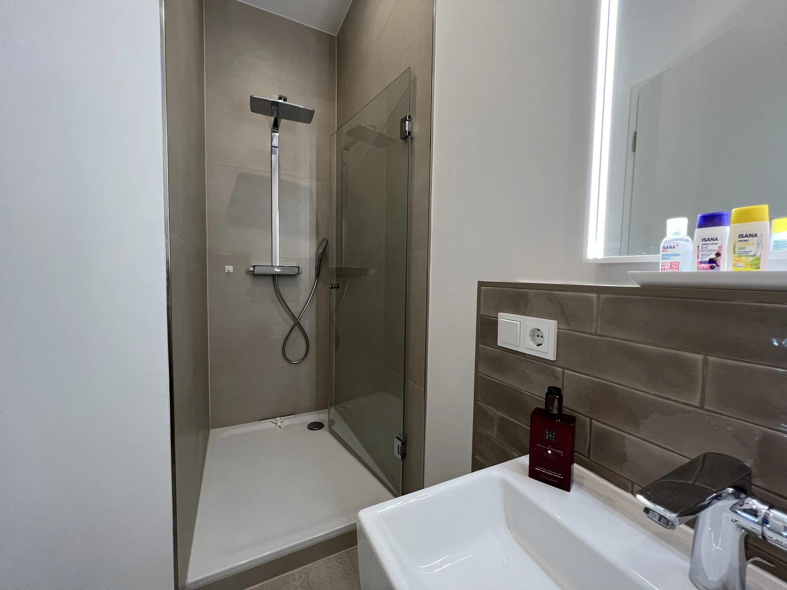 Bad der Bel-Étage-Wohnung der Villa Maria mit Walk-in-Dusche und Holz-Waschtisch, möbliertes Apartment in Bad Oeynhausen.