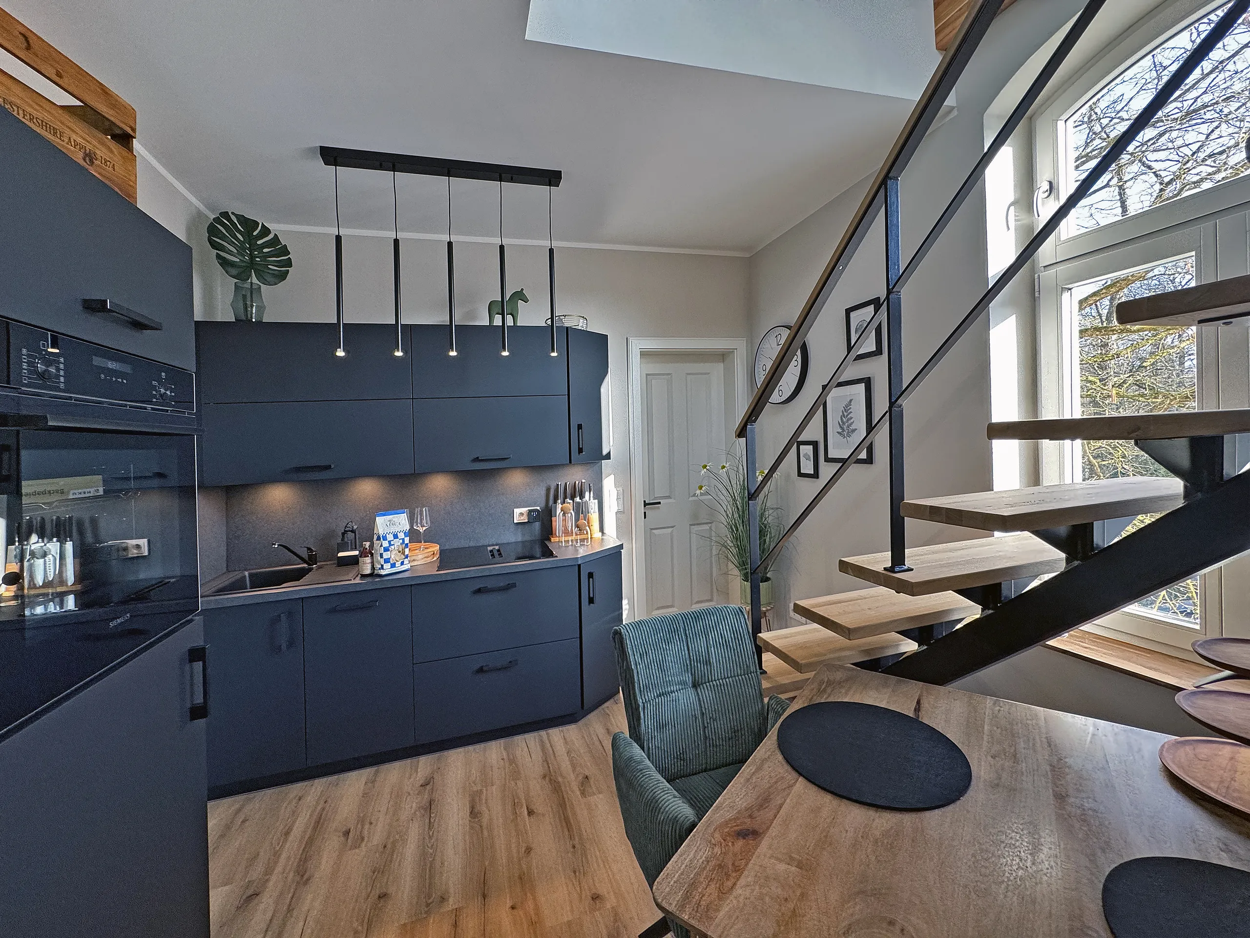 Dunkle Küche mit Maisonette-Treppe in der Wohnung Klara, möblierte Ferienwohnung in Bad Oeynhausen.