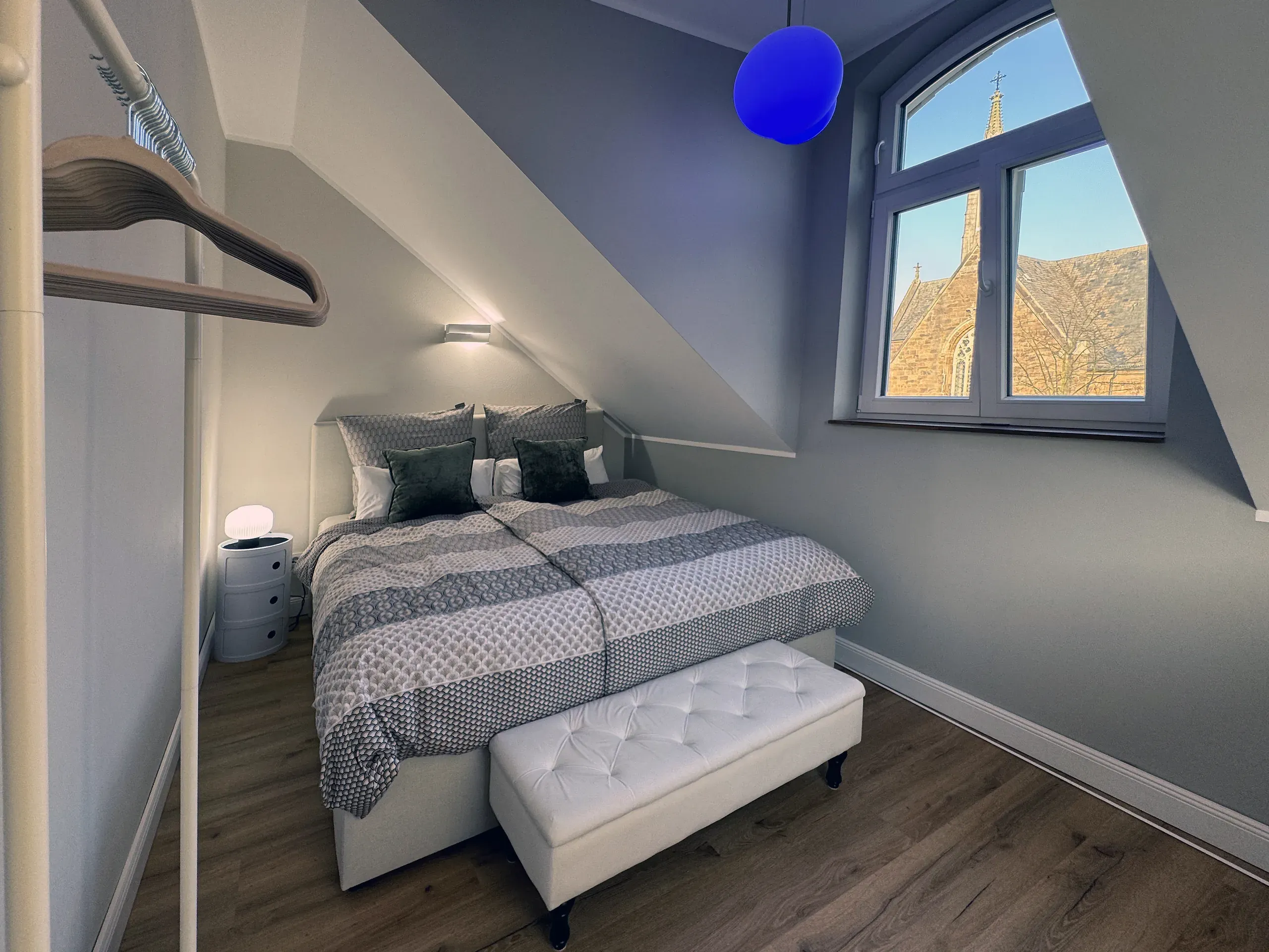Schlafzimmer der Maisonette Klara mit Doppelbett und Sitzbank, möbliertes Apartment in Bad Oeynhausen.